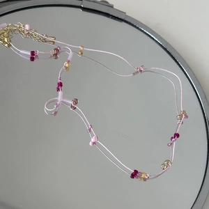 Détail du collier de perles roses avec perles translucides colorées et fermoir métal