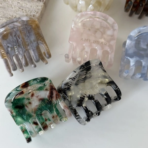 Collection de pinces à cheveux marbrées colorées avec logo sur fond blanc