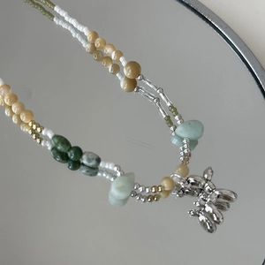 Gros plan d'un collier de perles fait main avec un pendentif chien ballon sur un miroir
