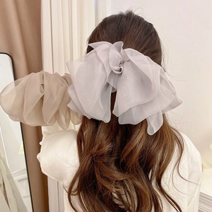 Detailed layered organza bow hair clip with translucent texture in champagne and grey