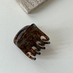 Détail macro d'une pince à cheveux en acétate écaille de tortue avec étiquette dorée