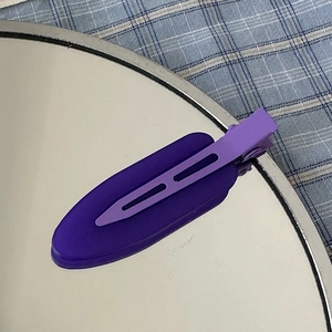 Detail view of purple matte seamless duckbill hair clip with textured layered design