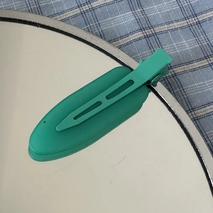 Detail of a mint green matte traceless hair clip with a stylish hollowed design