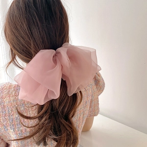 Elegant multi-layer pink chiffon bow hair clip shown on model for women's hair styling