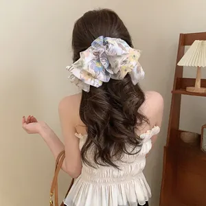 Detail of elegant floral chiffon oversized scrunchie hair accessory on model