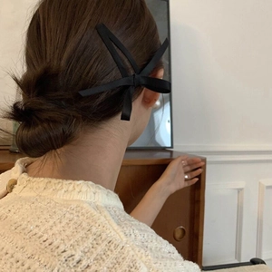 Elegante fermaglio per capelli con fiocco di raso nero su uno chignon basso stile francese