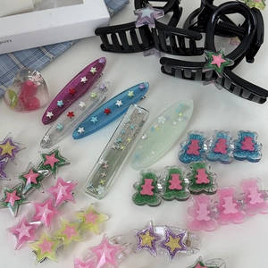 Vue macro de barrettes colorées en résine avec étoiles et oursons à paillettes