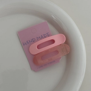 Détail de pinces à cheveux roses styles uni et gelée sur emballage carton avec vue macro
