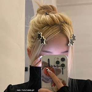 Détail de barrettes étoile Y2K noir et blanc portées sur les cheveux sur le côté