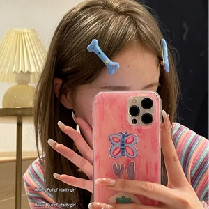 Gros plan de barrettes bleues en forme d'os avec étoiles jaunes dans un miroir