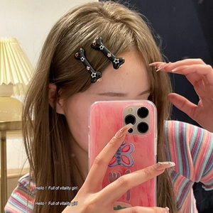 Gros plan de barrettes à cheveux en forme d'os avec motifs d'étoiles au style tendance y2k