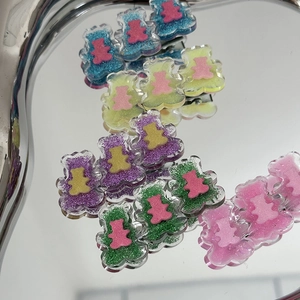 Détails de barrettes ours pailletées multicolores sur un plateau en métal argenté