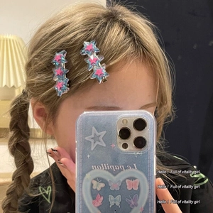 Gros plan de barrettes étoile Y2K scintillantes avec dégradé rose et bleu sur queue