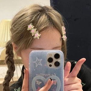 Selfie miroir montrant le lot de barrettes à cheveux en acrylique rose en forme d'étoile