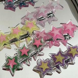 Gros plan de pinces à cheveux étoiles à paillettes avec clips crocodiles en métal