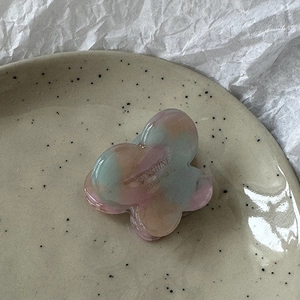 Detailed close-up of a butterfly acetate hair claw clip with colorful gradient marbling