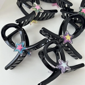 Gros plan de barrettes étoile Y2K avec paillettes sur une surface blanche pure