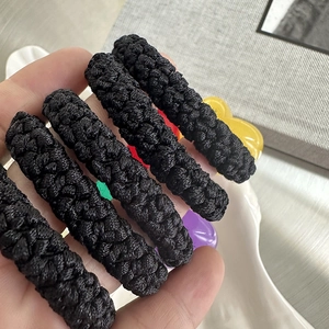 Close-up of thick woven black hair ties with colorful translucent heart resin charms