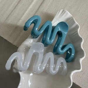 Detail of blue and white wavy hair claw clips made of high-quality resin material