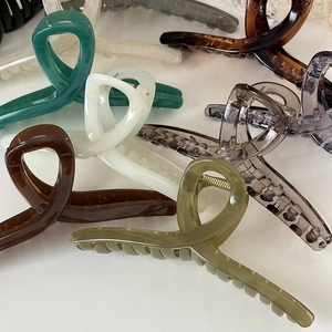 Macro di grandi fermagli per capelli da 14 cm in vari colori lucidi su sfondo bianco