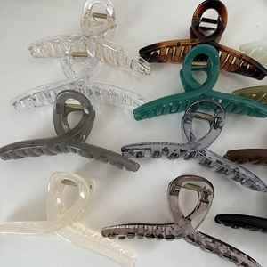Dettaglio delle grandi pinze per capelli da 14cm in vari colori opachi e trasparenti