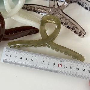 Dettaglio di pinze per capelli da 14 cm in vari colori con un righello di riferimento