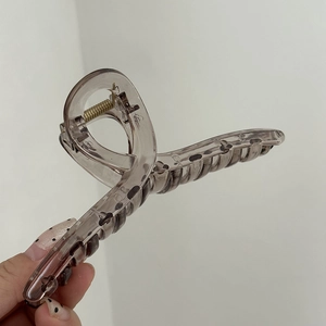 Dettaglio macro di un fermaglio per capelli da 14cm in resina grigio fumo con motivo leopardato