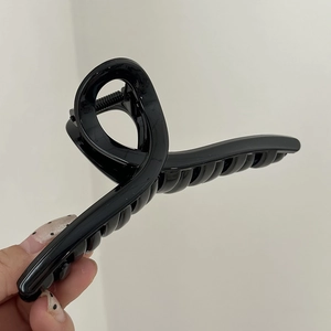 Dettaglio di una grande molletta per capelli nera lucida da 14cm con finitura liscia
