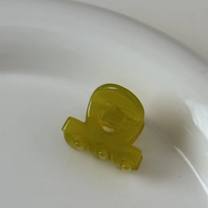 Gros plan sur une mini pince à cheveux en acétate vert olive avec texte MY BEAR