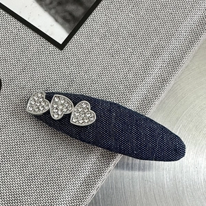 Detailansicht der blauen Denim-Haarspange mit drei funkelnden Herz-Strass-Verzierungen
