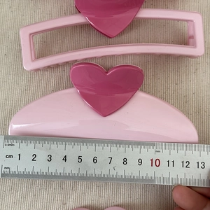 Detailed size measurement of pink heart hair claws with a ruler showing 13.5cm length