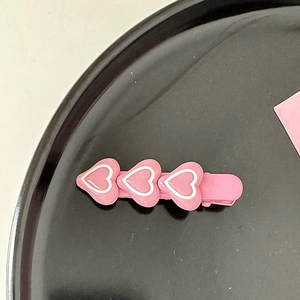 Gros plan de barrettes à cheveux roses en forme de cœur sur un plateau de présentation
