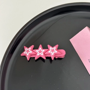 Détail de la pince à cheveux étoile rose Y2K avec design multicouche sur plateau