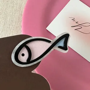Detail of cartoon fish hair clip in pink and blue acetate with marble texture finish
