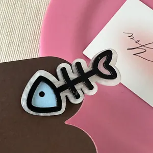 Detailed macro view of a cute resin fishbone hair clip in blue and pink pastel colors