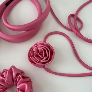 Pink satin hair accessories set including padded headband, flower ribbon, and scrunchie