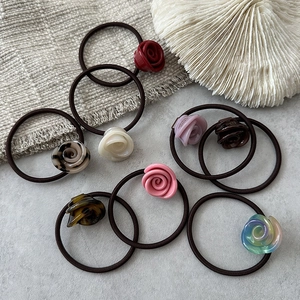 Set di otto eleganti elastici per capelli a forma di rosa in vari colori su base grigia