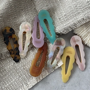 Collection of wave-edge acetate hair clips in eight colors with handmade lettering detail