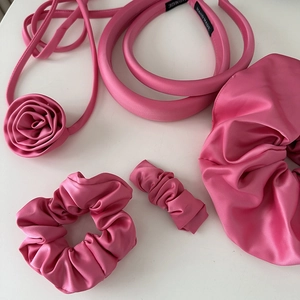 Detail of pink satin hair accessories set featuring scrunchies and fabric headbands