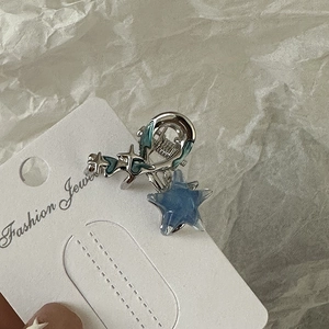Détail macro de la pince à cheveux étoile Y2K avec paillettes bleues et métal argenté