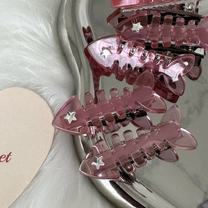 Pink fishbone y2k hair clips with silver star accents on a white faux fur background