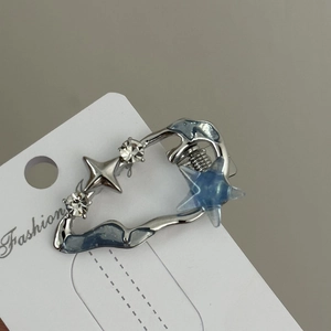 Détail macro d'une pince à cheveux Y2K en alliage argenté avec étoile bleue et strass
