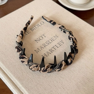 Detail view of leopard print headband with sparkling rhinestones and black punk spikes