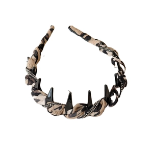 Leopard print headband with rhinestone accents and punk style spikes on white background