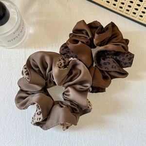 Lot de deux chouchous en satin marron et imprimé léopard sur fond de tissu blanc