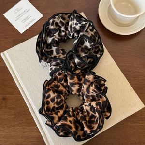 Fashionable leopard print 4-layer scrunchie set with black stitched edges on white book