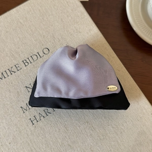 Detail of lavender and black satin hair claw clip with golden LUCKY metal charm label