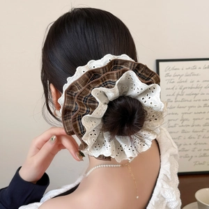 Chouchou à carreaux marron avec dentelle blanche brodée porté sur un chignon