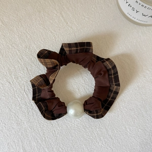 Detailed view of coffee brown plaid scrunchie featuring an elegant large white pearl accent