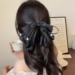Pince à cheveux noire élégante avec ruban scintillant et perles sur cheveux bouclés